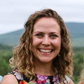 Photo portrait of Megan Carter-Lapp with a blurred green hill in the background