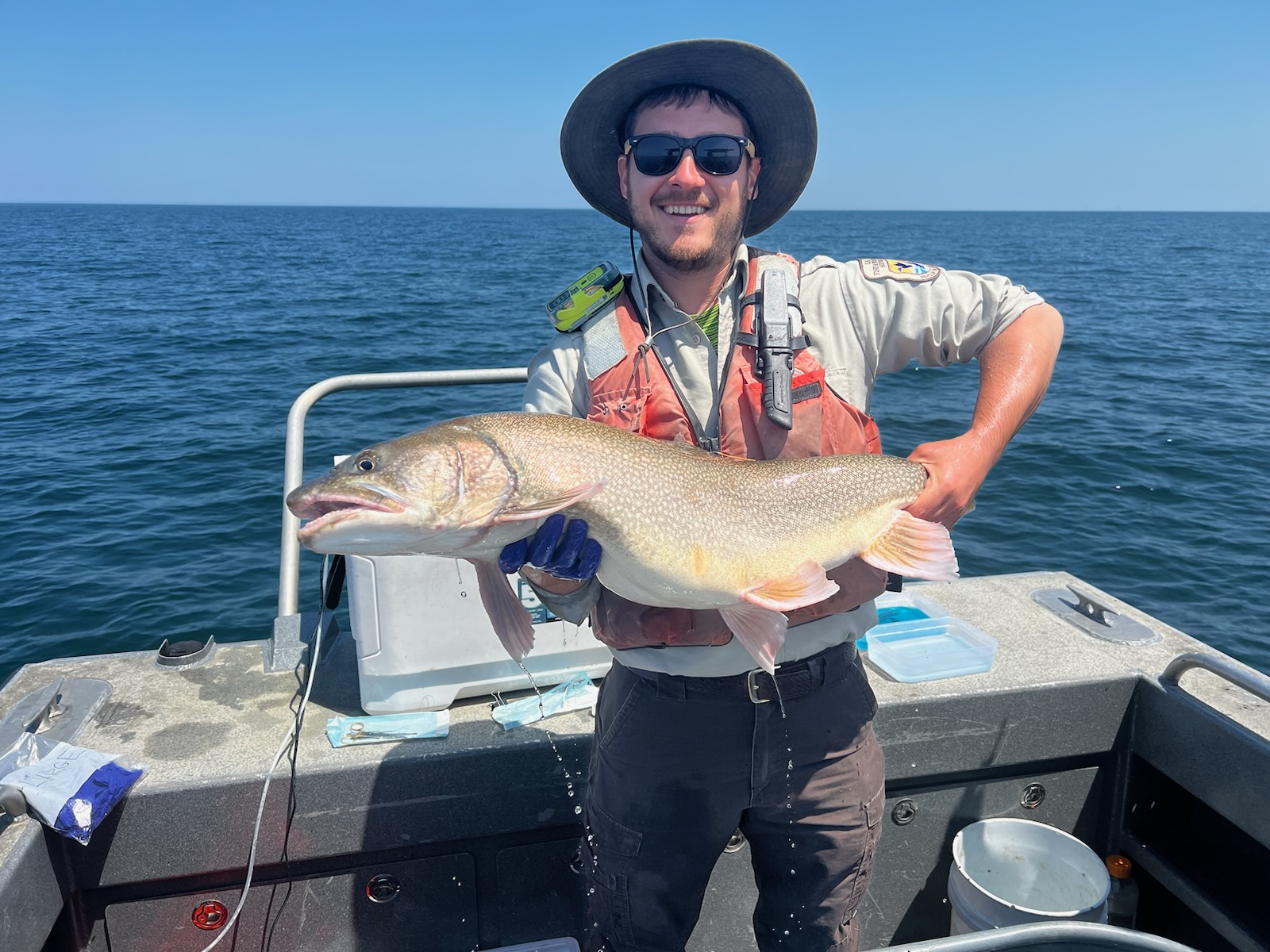 Greg Kronisch on a boat in open water, holding a large fish