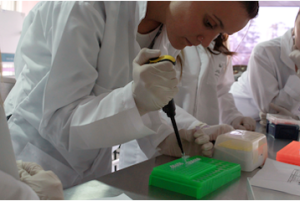 Young woman in lab coat working on samples