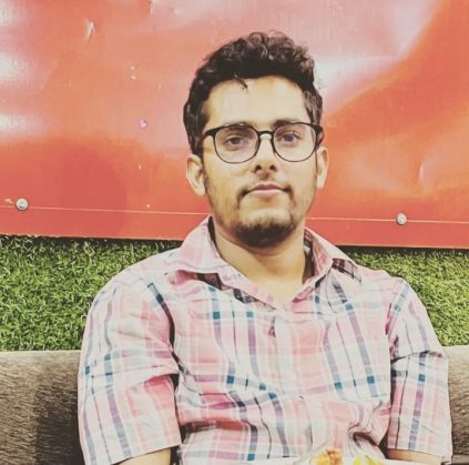 Photo of Keshav Bagale, wearing glasses and a plaid shirt.