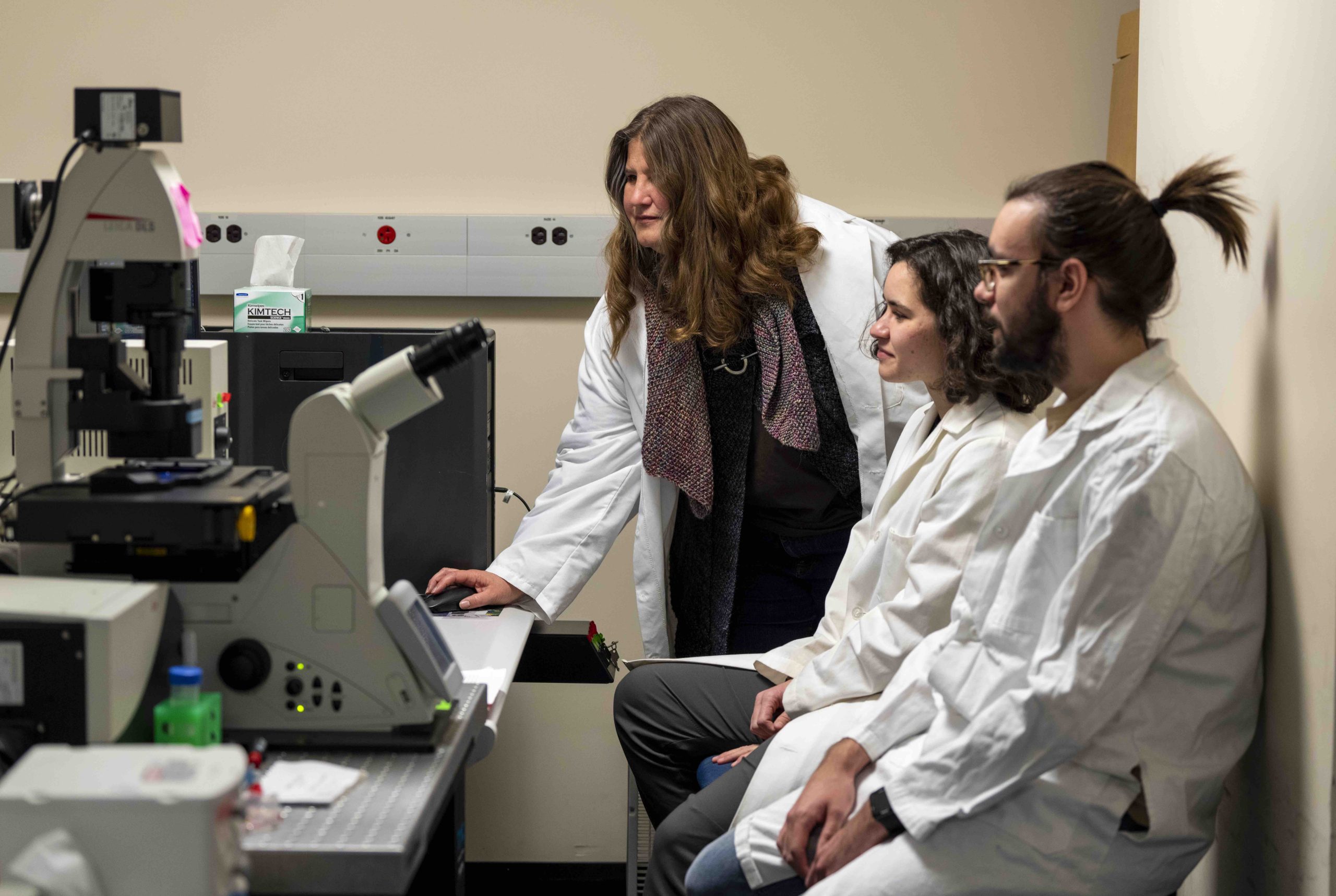 Clarissa Henry shows students students how to use microscope