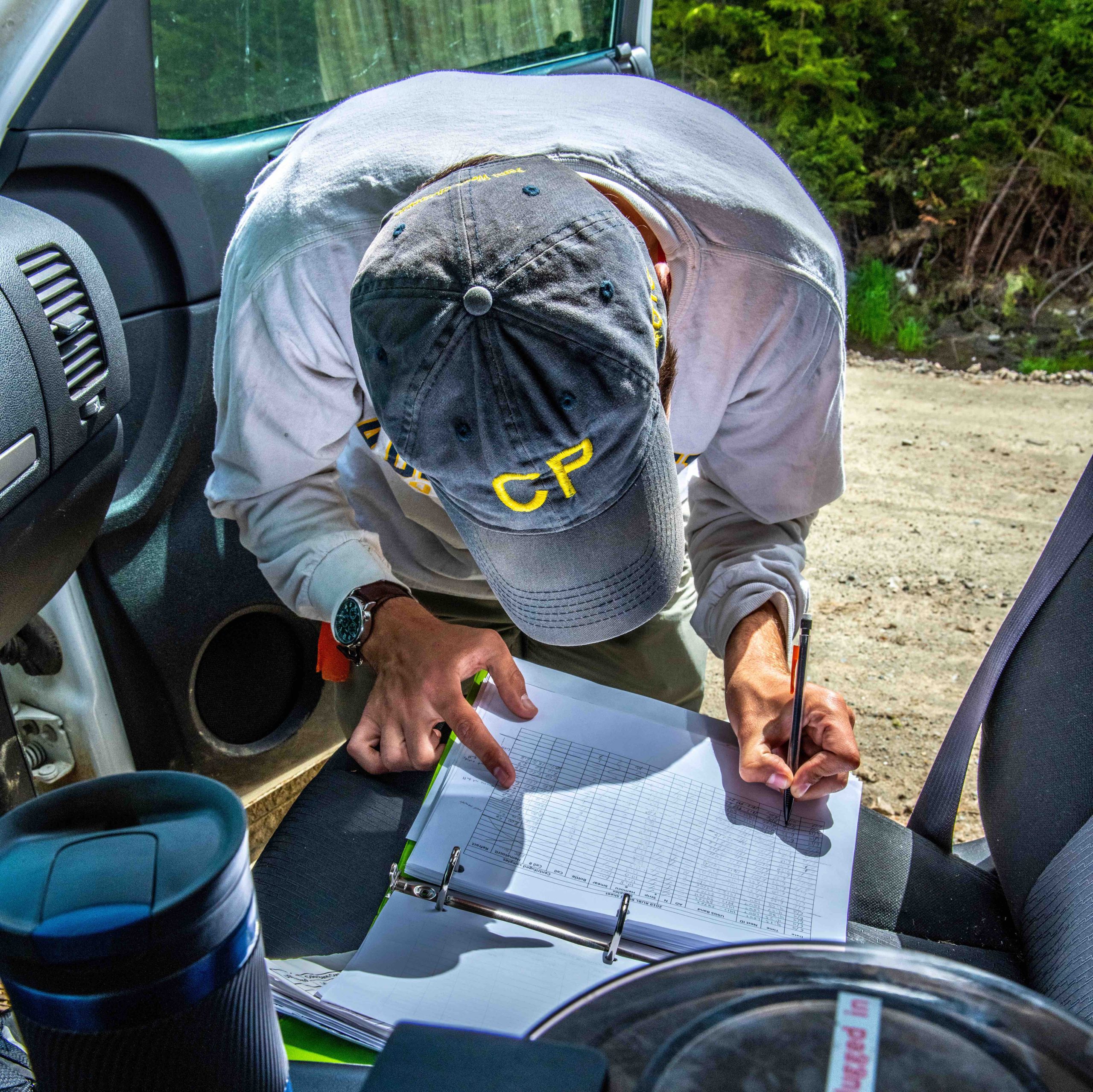 Student field worker records data in field notebook